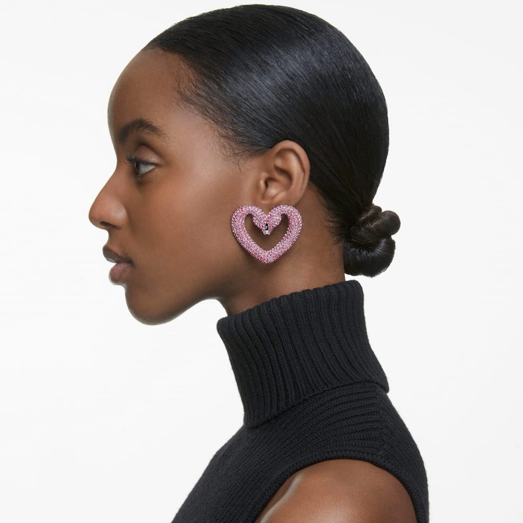 Mannequin femme de profil portant une boucle d'oreille XXL forme coeur à strass rose